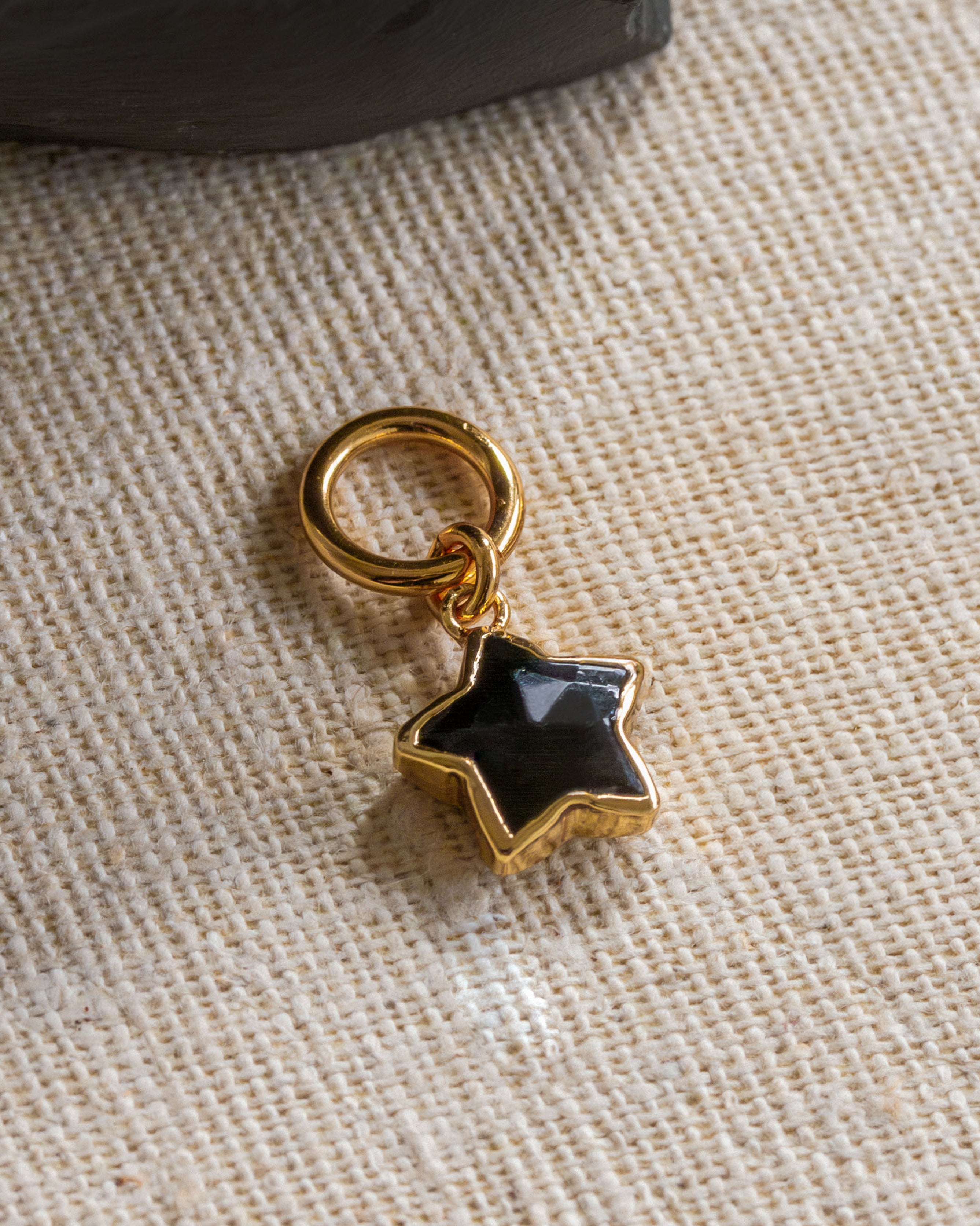 Gold plated hoop earring wit black onyx star shaped charm.