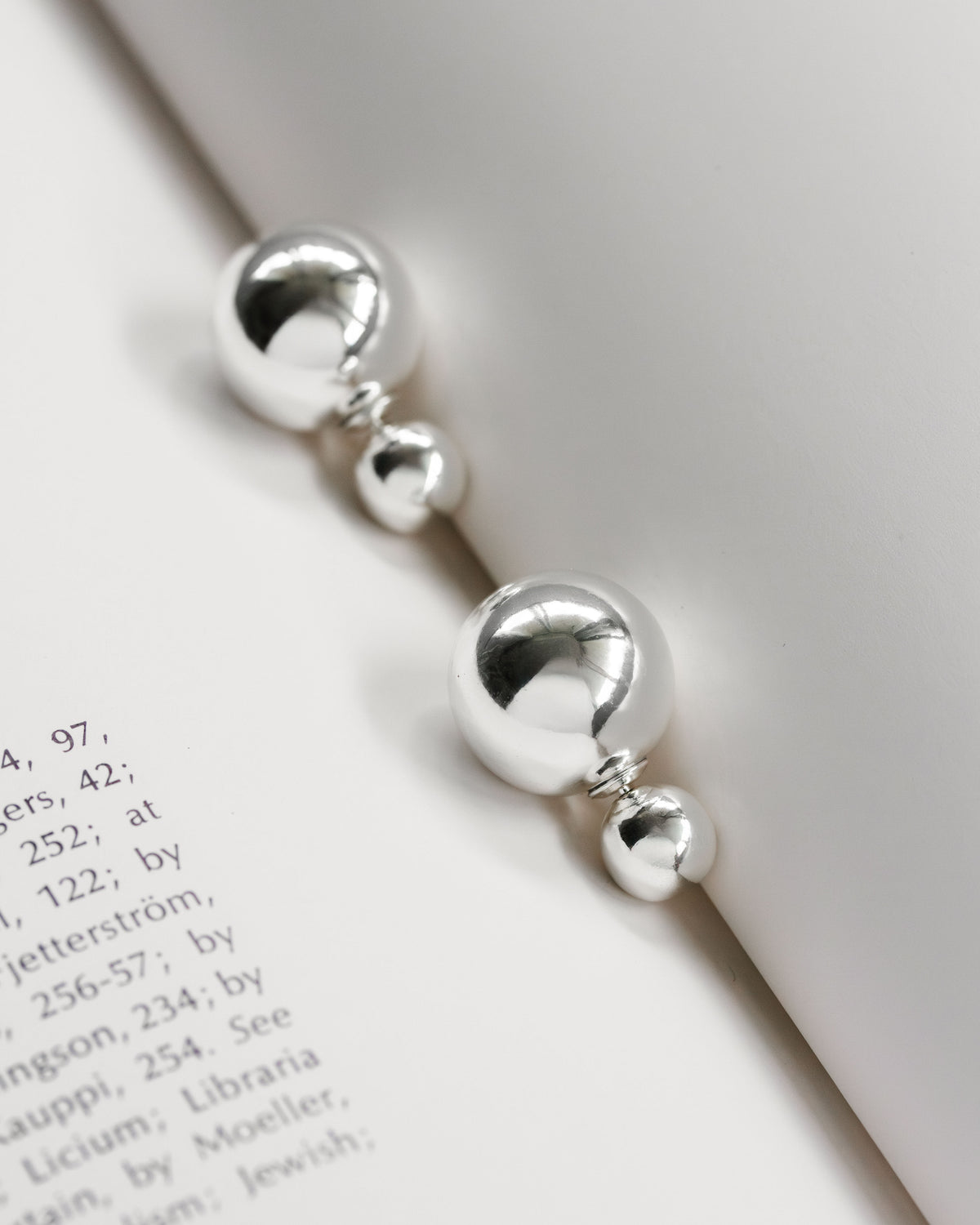 Silver front-back earrings with a polished finish and orb backings