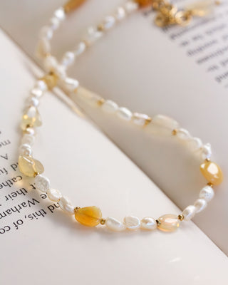 Necklace with pearls and opal beads on a book page