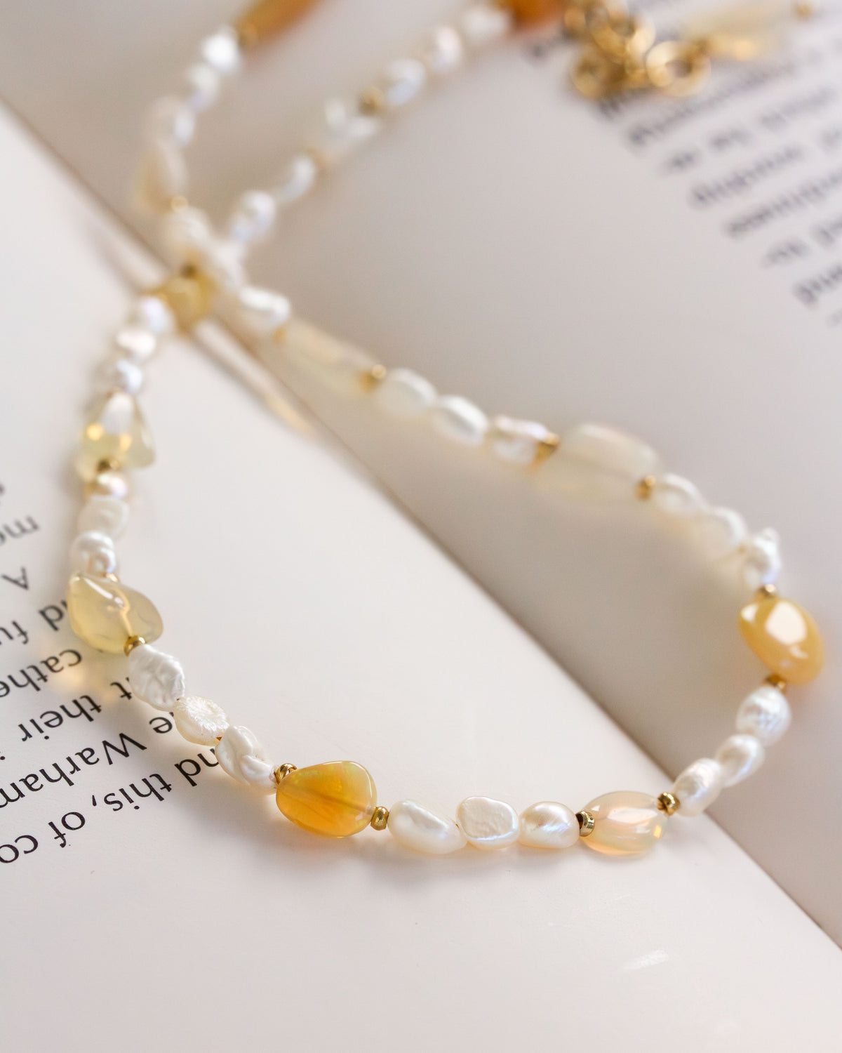 Necklace with pearls and opal beads on a book page