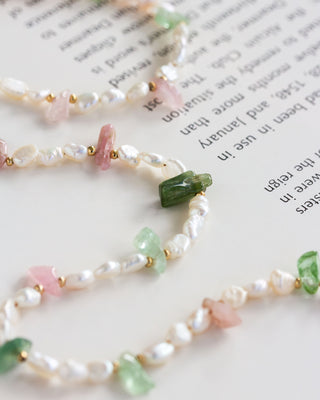 Pearl and gemstone necklace on a book page