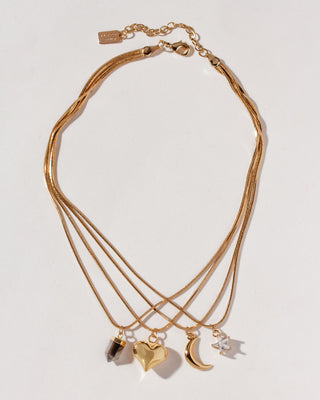 Multilayered gold necklace with star, moon, heart, and pendant charm.