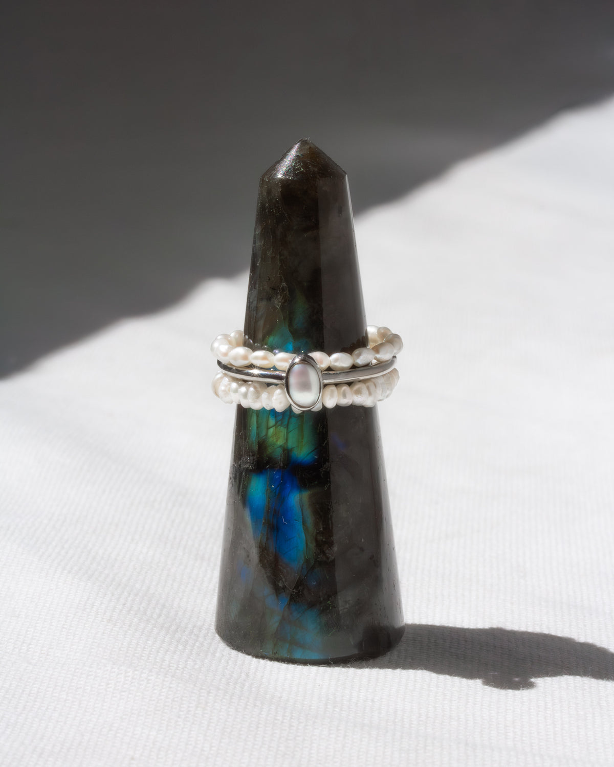 Three rings stacked on a black and blue crystal on a white surface