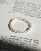 White pearl ring on top of book page.