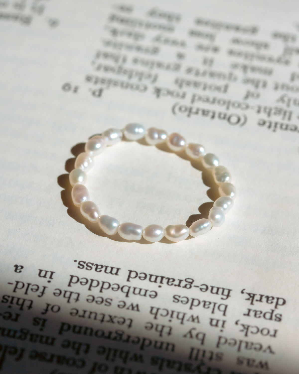 White pearl ring on top of book page.