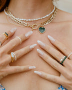 Hands wearing Coastal Stretch Rings: Freshwater Pearl, and Genuine Stone rings.