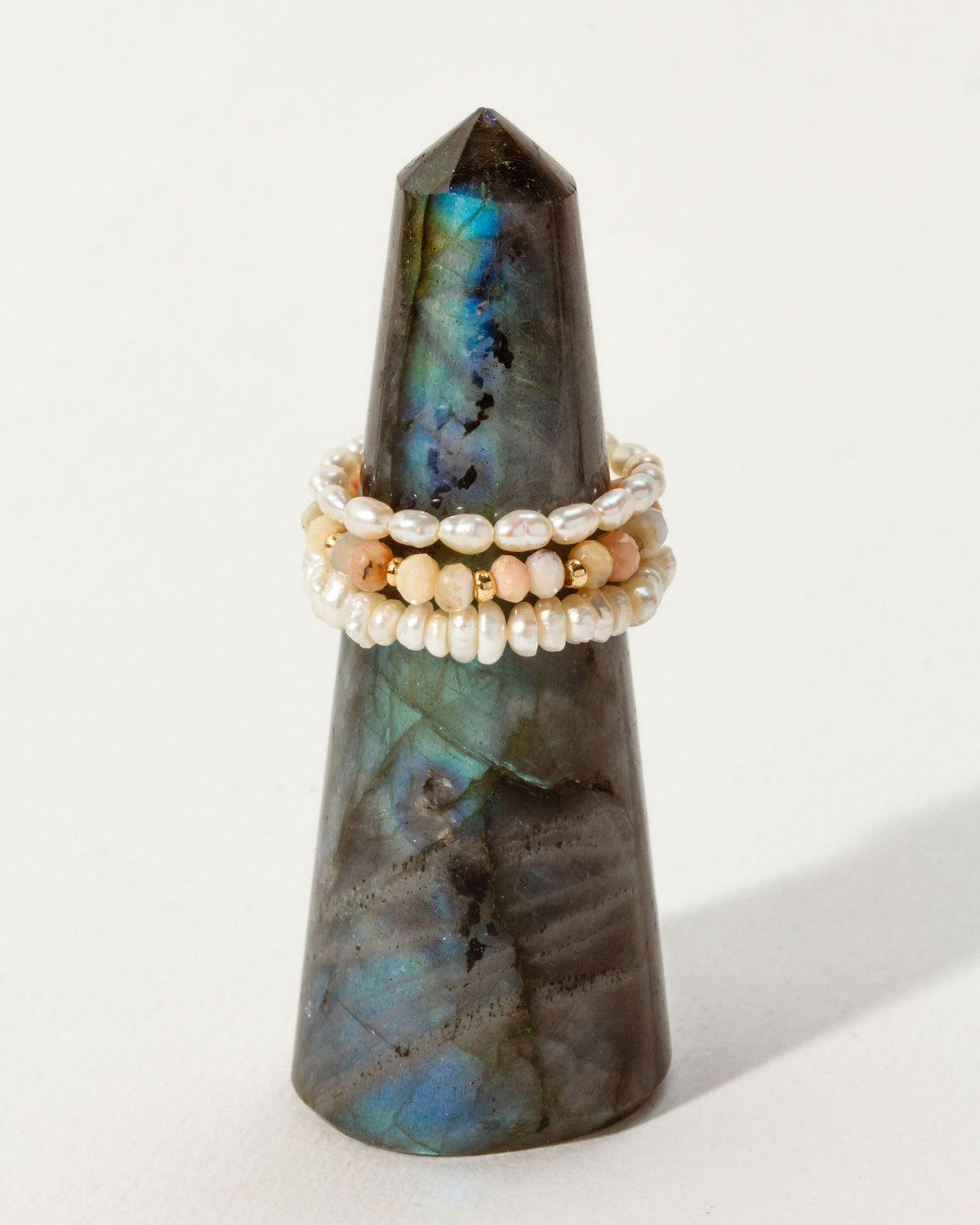 Three stacked, stretchy rings with pearls and Peruvian Opal beads on a Labradorite tower.
