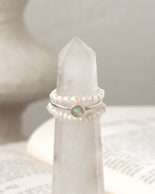 Three stacked rings on a white crystal with a neutral background