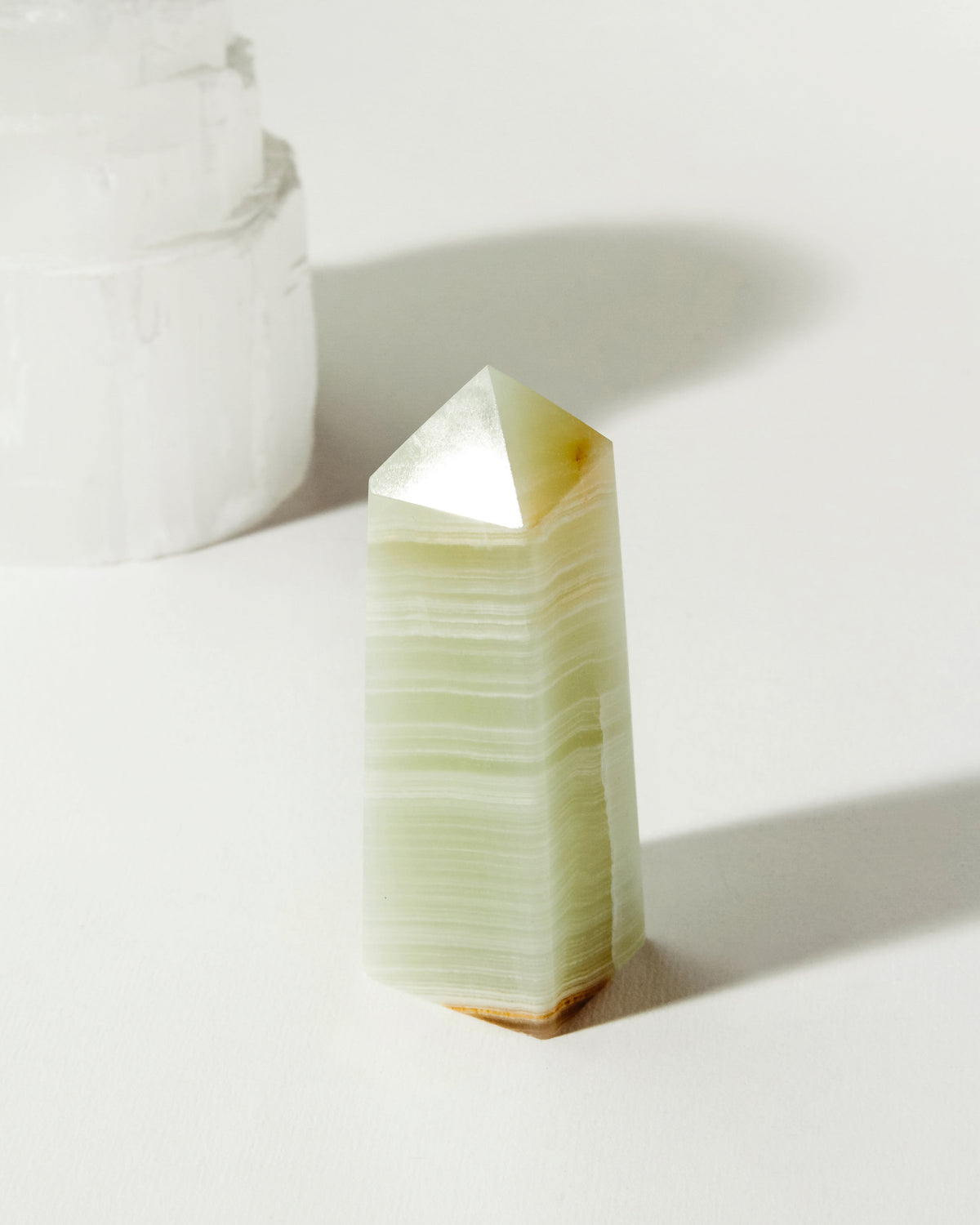 Banded Calcite Obelisk crystal with neutral and green tones.