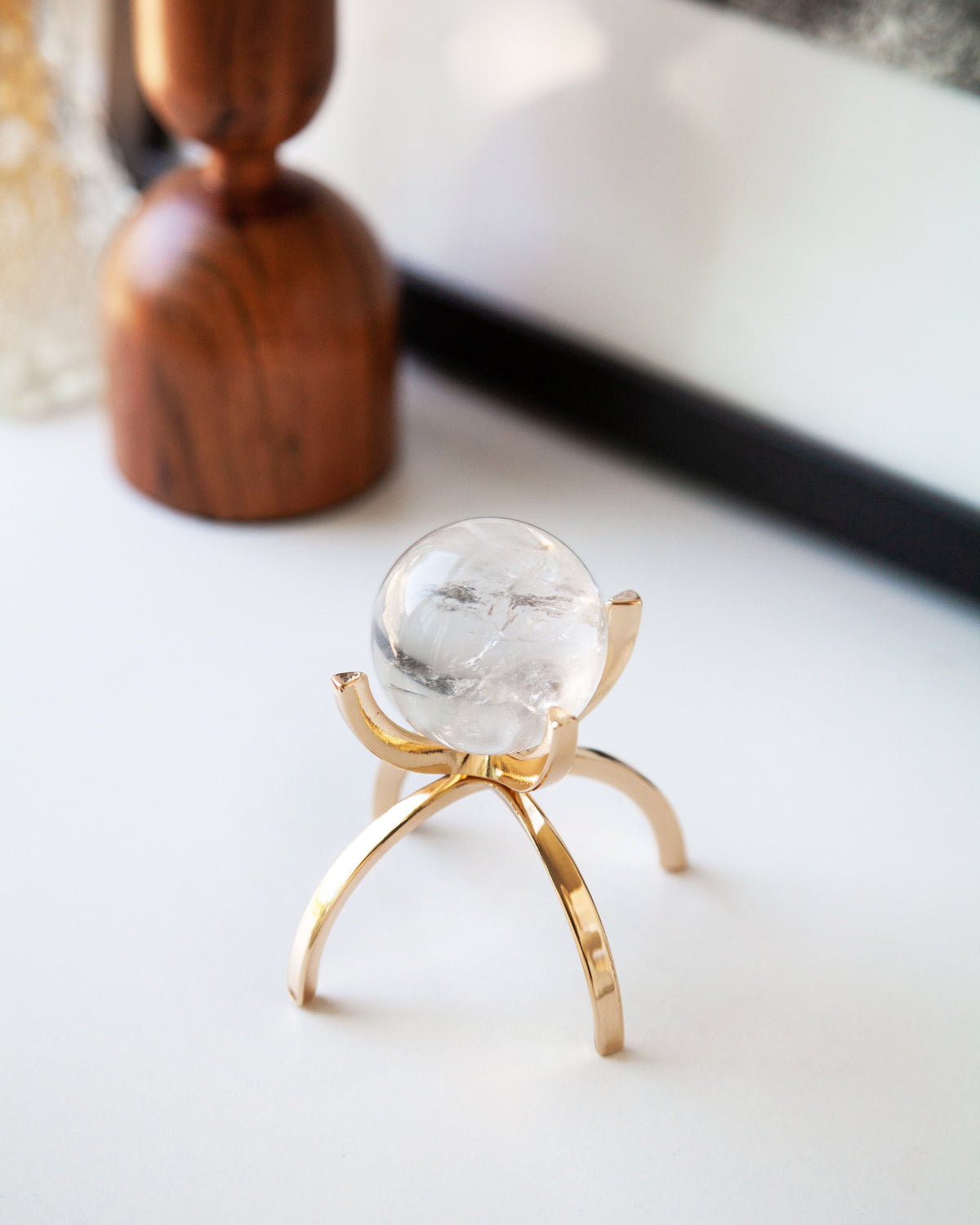 Clear Quartz sphere on a gold stand.