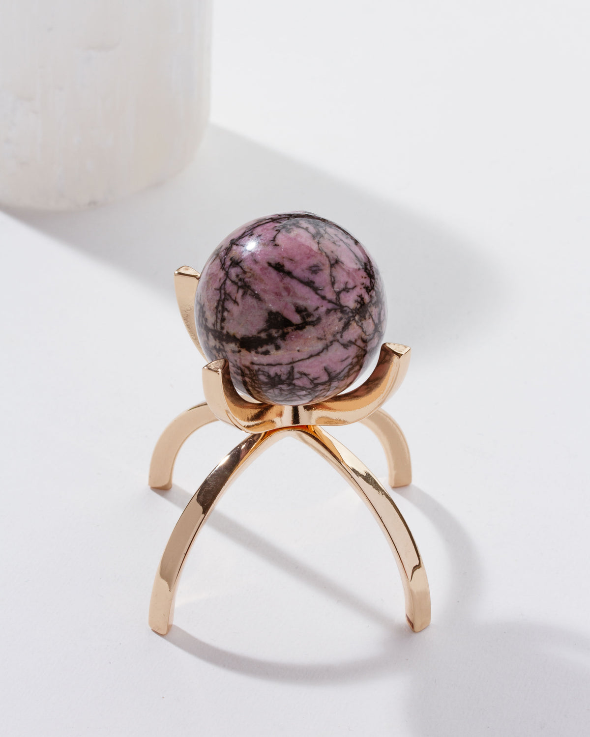 Eye Of the Beholder Gemstone Sphere On Stand Set, with the Rhodonite stone, set on a gold stand.