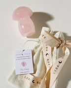 Rose Quartz mushroom crystal next to Luna Norte branded bag.