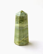 Serpentine Tower with a light green coloring and distinct layering on a white background.