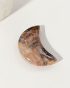 Waxing crescent moon-shaped brown moonstone gemstone with a polished surface.