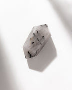 Tourmalinated quartz has a clear and black needle-like inclusions on white background.