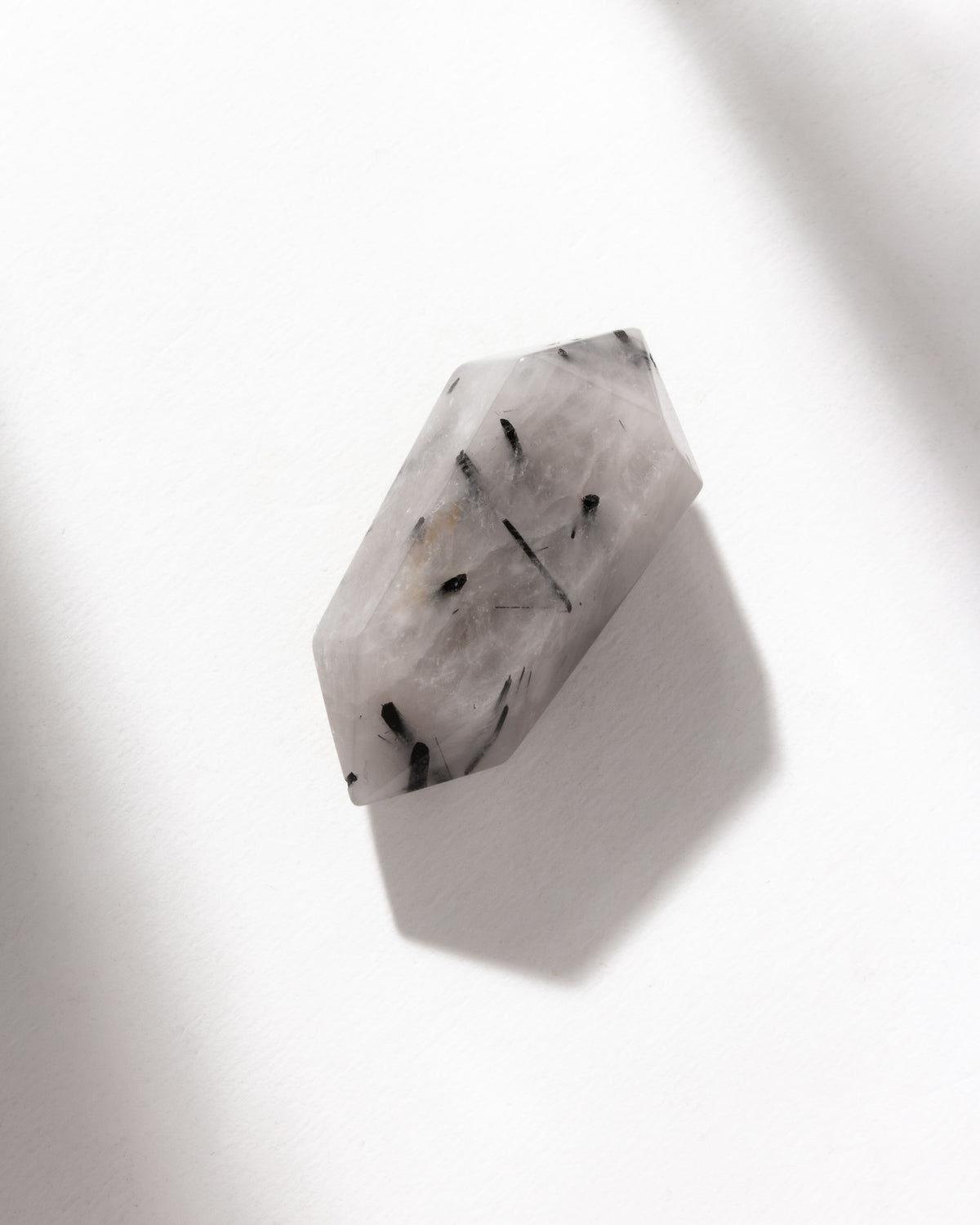 Tourmalinated quartz has a clear and black needle-like inclusions on white background.