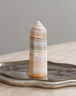 Decorative crystal tower on a metallic tray with a neutral background