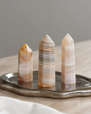 Three crystal towers on a metallic tray with a neutral background