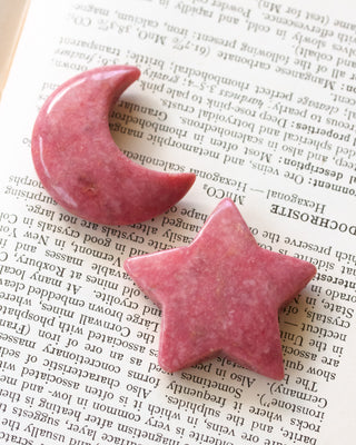 Pink stone star and crescent moon on a book page