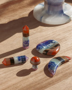 Arrangement of five colorful multilayered gemstone curios on a wooden surface