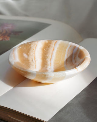 Decorative stone bowl with striped pattern on a light background