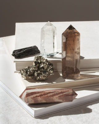 Set of 5 natural crystals and gemstone's displayed on a book.