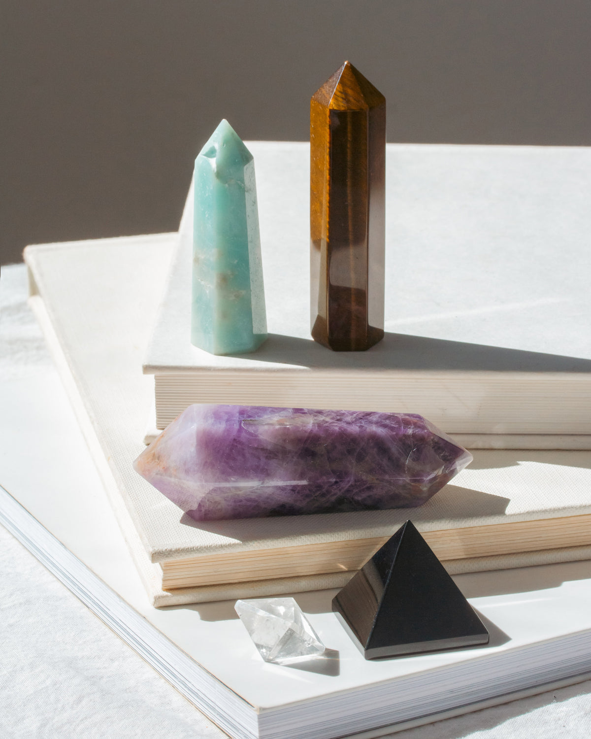Set of 5 gemstone curio tower and pyramid shapes displayed on a book.