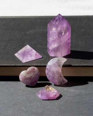 Amethyst Set brings together 5 genuine amethyst curios.

Featuring a heart, crescent moon, standing tower, pyramid, and geometric palm size stone, each piece highlights a different shape while celebrating the rich violet hues and natural character of genuine amethyst. The collection combines pocket sized treasures with a medium sized tower.