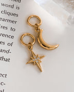 Two gold interchangeable earring charms, one shaped like a crescent moon and the other like a star