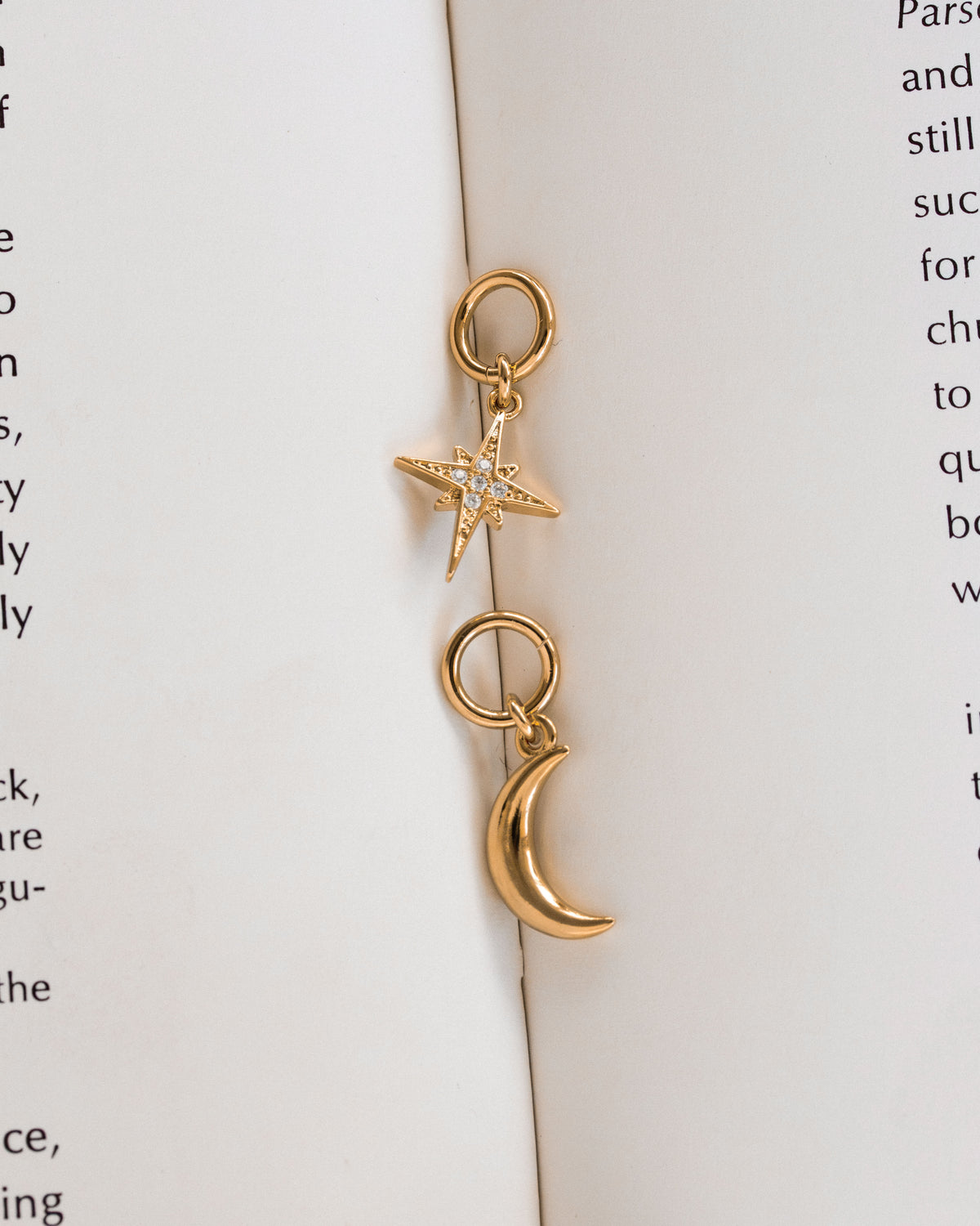 Pair of gold hoop earrings, one in the shape of a crescent moon, the other a star with CZ elements
