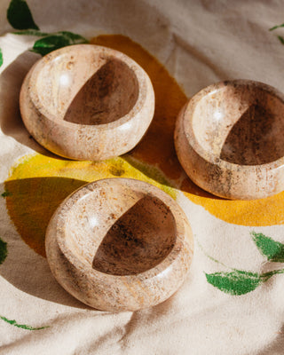 Three Calcite jewelry catchall bowls on a floral motif cloth.
