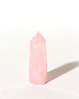 Rose quartz gemstone, mini tower standing on white background.