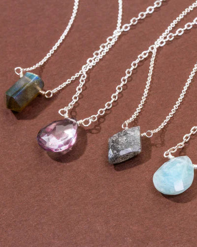 Examples of silver necklaces with various shapes and colorful gemstone pendants