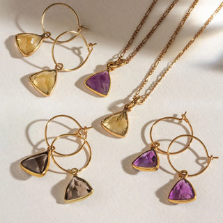 Flat lay of "Bermuda" earrings and Necklaces collection with smoky quartz, amethyst, and citrine stones.