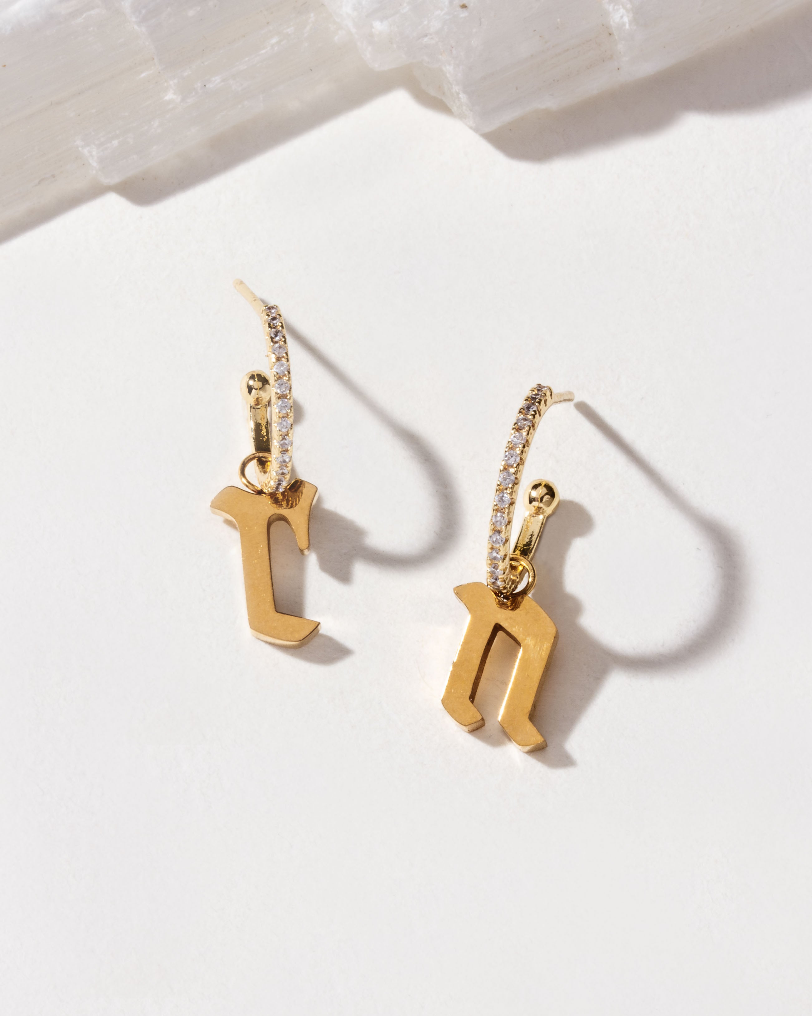 Gold initial hoop earrings with the letters "r" and "n".