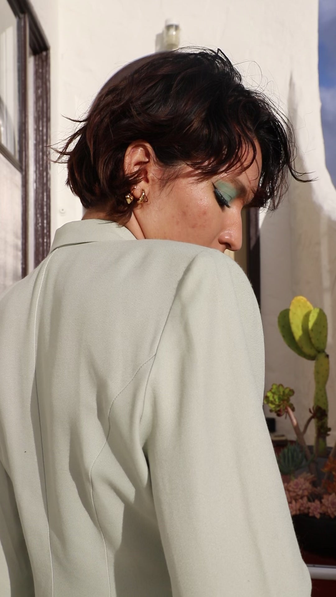 Person models gold earrings and necklace.