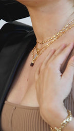 Woman models layered gold necklaces with coffee moonstone pendant.