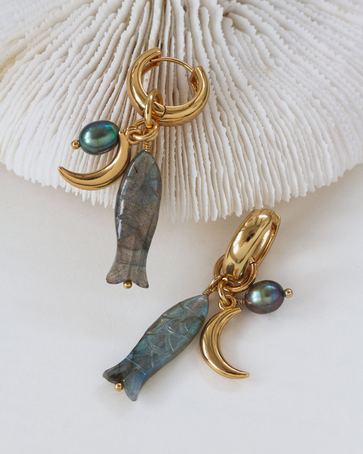 Close-up of the Tapas & Tides huggie hoop earring shows the labradorite charm