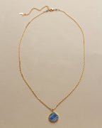 Bohemian Long Medallion Necklace with a Kyanite pendant on a gold chain.