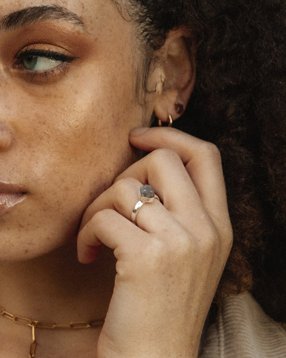 Close-up of a hand wearing an Aurora Labradorite ring in Sterling Silver.