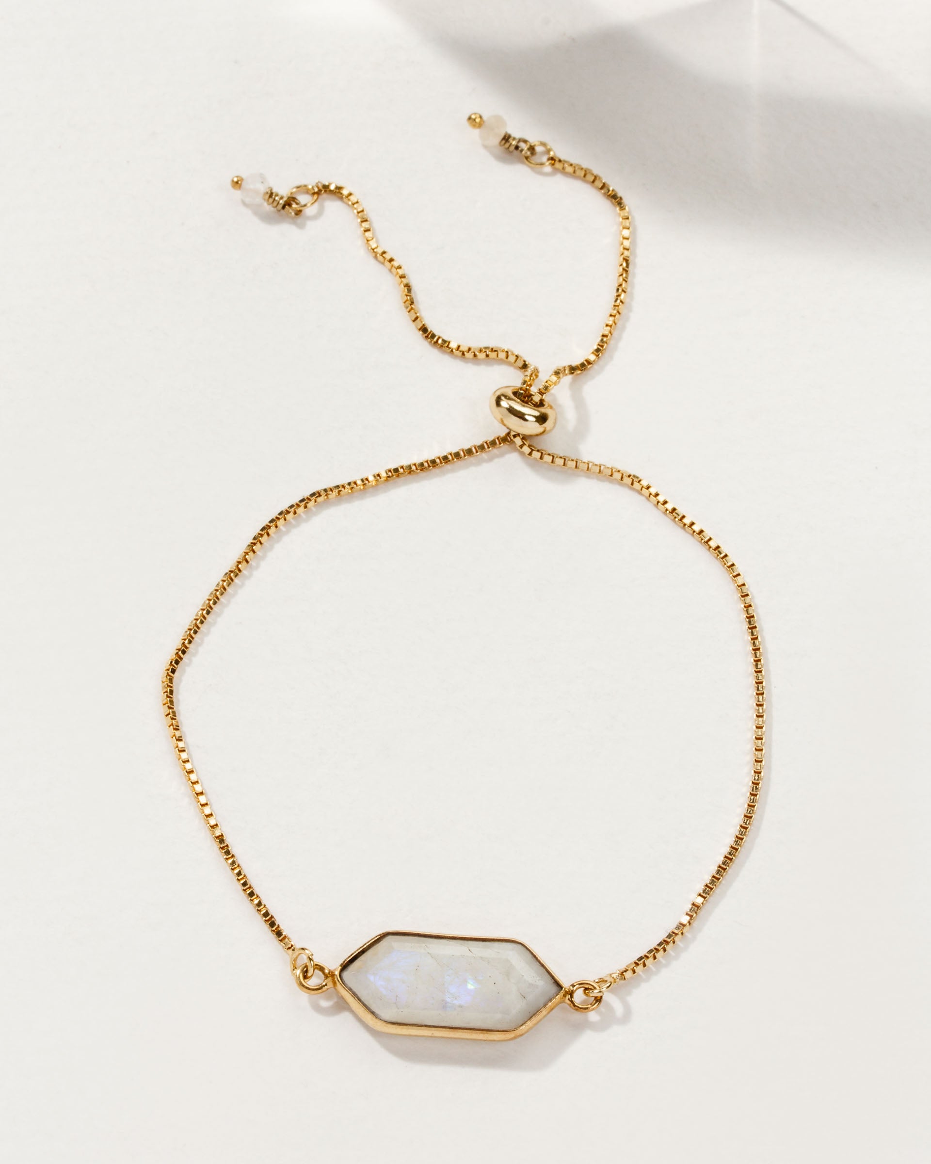 Adjustable gold bracelet with a Moonstone gemstone, reminiscent of the Northern Lights.