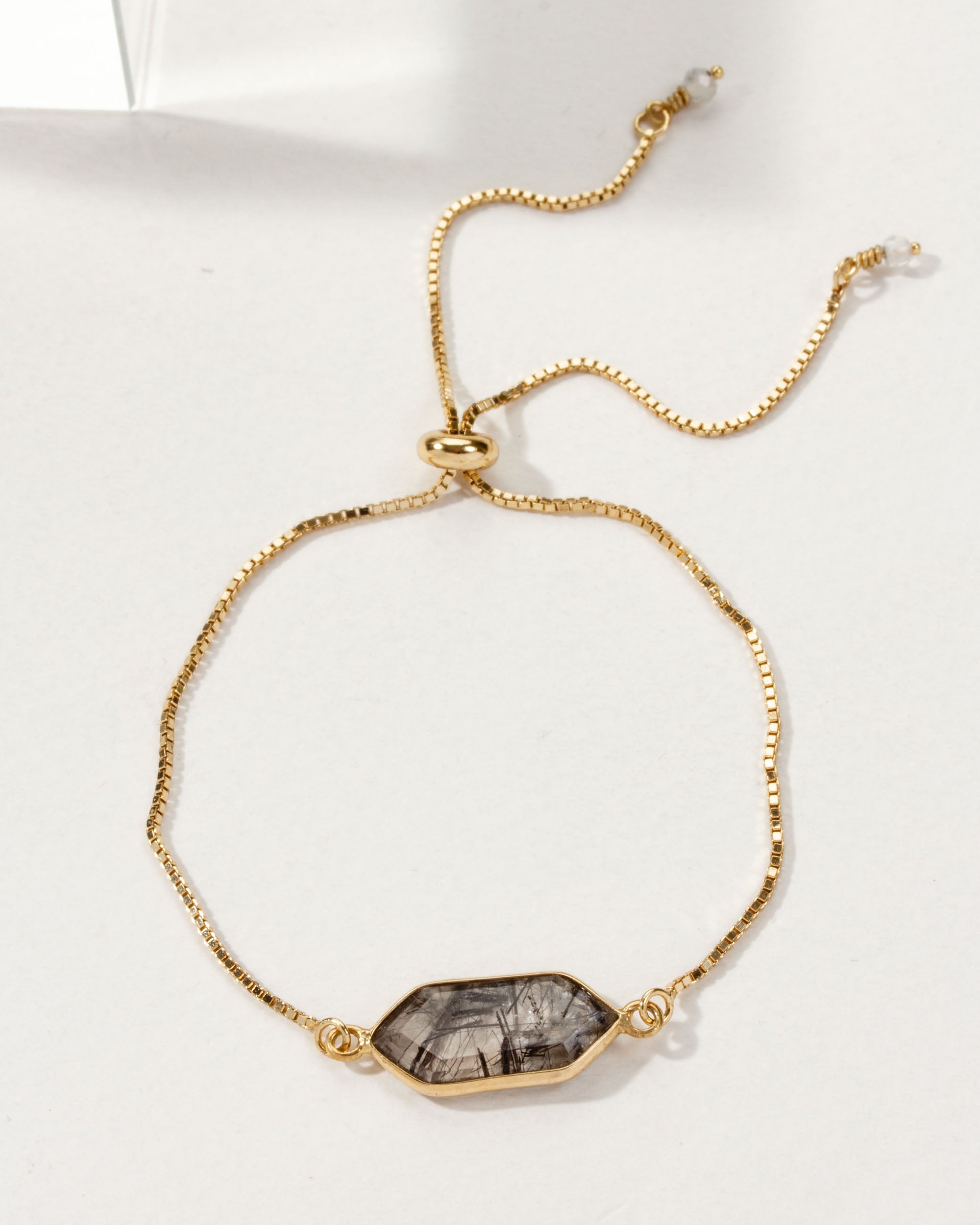 Gold adjustable bracelet featuring a tourmalinated quartz gemstone.