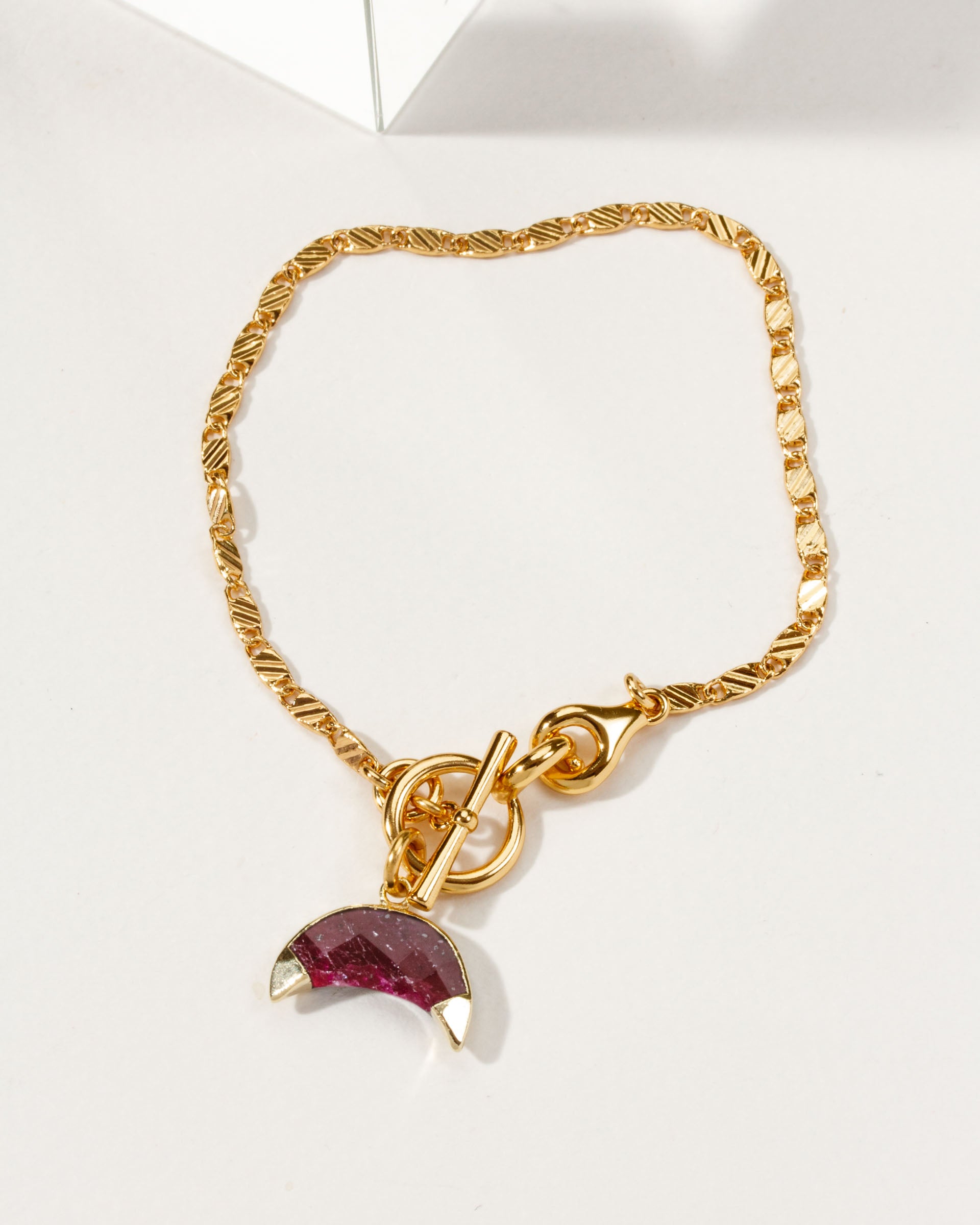 Gold Crescent Horn Toggle Bracelet with a ruby gemstone crescent horn charm.