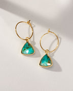 Two gold Bermuda Triangle Mini Hoops with turquoise stones are on a white surface.