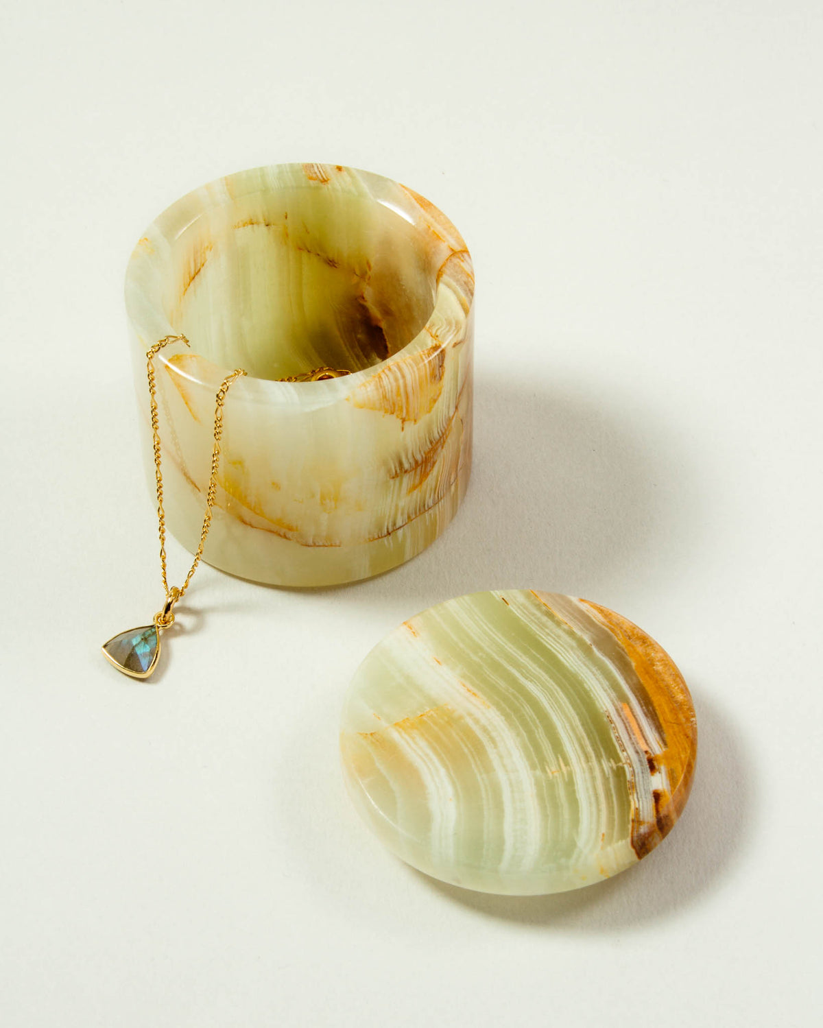 Open green calcite jewelry box with necklace on a white background.