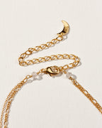 Closeup of necklace clasp displayed on a white surface.