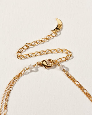 Closeup of necklace clasp displayed on a white surface.