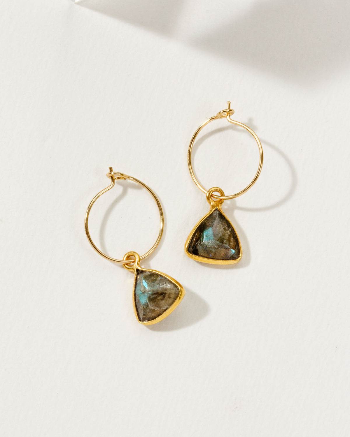 Two gold Bermuda Triangle Mini Hoops with Labradorite stones, displayed on a white surface.