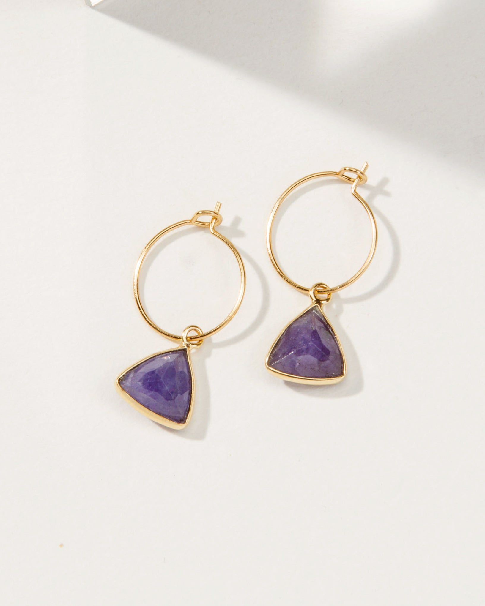 Pair of gold mini hoops with Amethyst triangle stones.