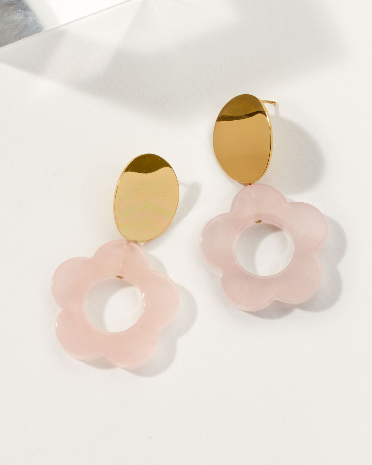 Oops-A-Daisy earrings with gold hardware and rose quartz carved gemstone in a flower shape.